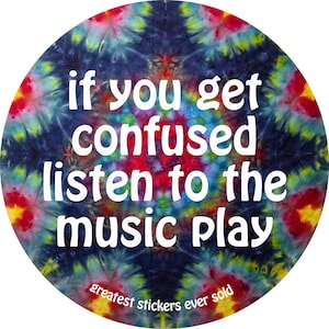 May include: A circular sticker featuring a vibrant tie-dye pattern in shades of blue, red, yellow, and green. The text reads, "if you get confused listen to the music play" in white, with "greatest stickers ever sold" in smaller white text below.