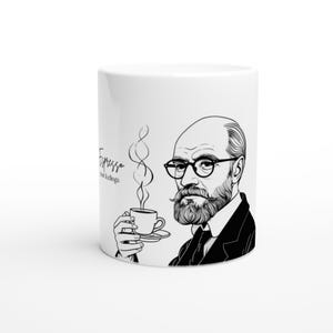 Könnte beinhalten: Weiße Keramik-Kaffeetasse mit einer Schwarz-Weiß-Illustration eines Mannes mit Brille und Bart, der eine Tasse Kaffee hält. Auf der Tasse steht in Schreibschrift der Text "Espresso your feelings".