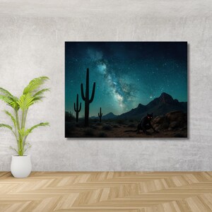 以下が含まれることがあります： 星空の下の砂漠の風景を描いたキャンバスプリント。サボテンのシルエットが前景にあり、中央には赤い目の黒いパンサーがいます。背景には山があります。
