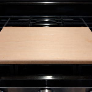 Maple cutting board on a stove top