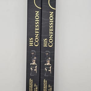 May include: Two black perfume boxes with gold accents and the text "HIS CONFESSION". Each box displays a perfume bottle illustration and the text "EAU DE PARFUM NATURAL SPRAY VAPORISATEUR 1.18 FL. OZ. / 35 mL e".