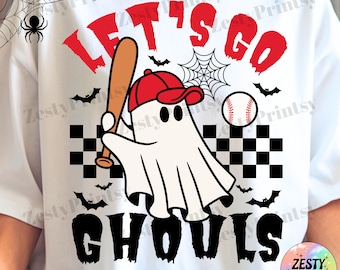 May include: White t-shirt with a Halloween-themed graphic. The design features a ghost wearing a red baseball cap and holding a bat, with the words "LET'S GO GHOULS" in red and black. A baseball and bats are also included.