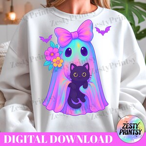 May include: White sweatshirt with a cartoon ghost design, holding a black cat and adorned with a bow, flowers, and bats. The design features a digital download text at the bottom. The artwork uses a vibrant palette of pink, purple, and blue hues.