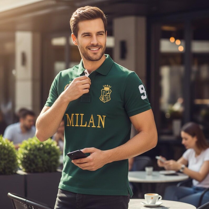 May include: A dark green short-sleeved polo shirt featuring the word MILAN in gold lettering across the chest, a gold crest emblem with a crown above it, and the number 9 in white on the left sleeve. The shirt has a collar and a button placket.
