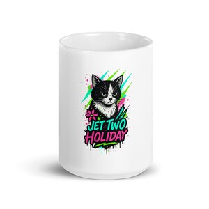 Könnte beinhalten: Weißer Keramikbecher mit einer schwarz-weißen Katzenillustration und dem Text "JET TWO HOLIDAY". Das Design enthält pinke, grüne und blaue Elemente im Graffiti-Stil.
