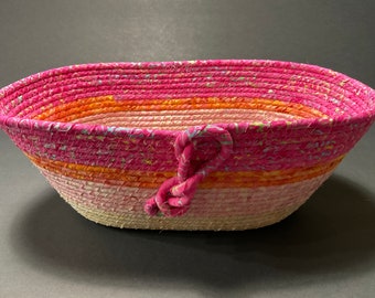Cesta decorativa para tender la ropa con tejido batik rosa y cuerda enrollada ovalada