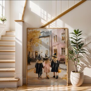 May include: A framed painting depicts three children in witch costumes walking down a street. The children are holding hands and carrying jack-o'-lantern buckets. The painting has a gold frame and is displayed in a well-lit hallway.