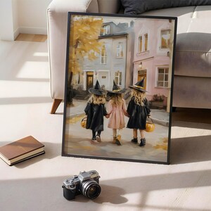May include: Framed art print depicting three children in witch costumes walking down a street. The children are holding hands and carrying jack-o'-lantern buckets. The artwork has a soft, painterly style with autumn colors.