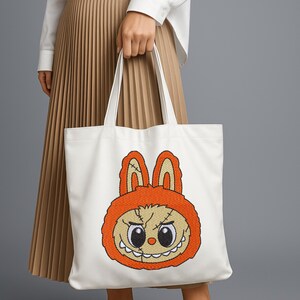 White tote bag featuring orange kawaii monster bunny embroidery design – cute cartoon-style machine embroidery mockup for accessories