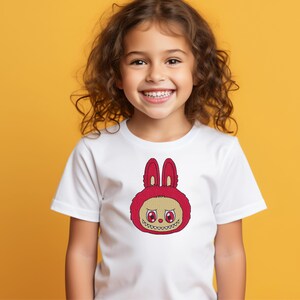 Smiling child wearing white t-shirt with red kawaii monster bunny embroidery – cute kids cartoon embroidery design mockup