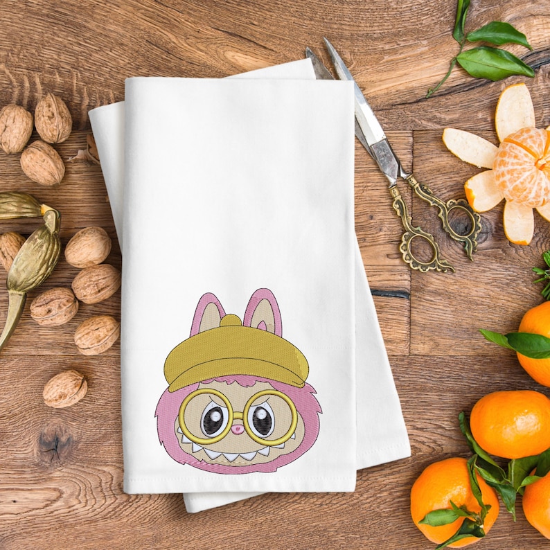 White tea towel with pink kawaii monster bunny embroidery wearing yellow hat and glasses – cute home decor embroidery mockup