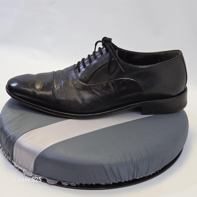 Puede incluir: Un zapato oxford de cuero negro con puntera, que presenta un cierre de cordones con cordones negros finos y un tac&oacute;n bajo apilado. El zapato tiene un acabado liso y pulido y una silueta estructurada con un dise&ntilde;o cl&aacute;sico.