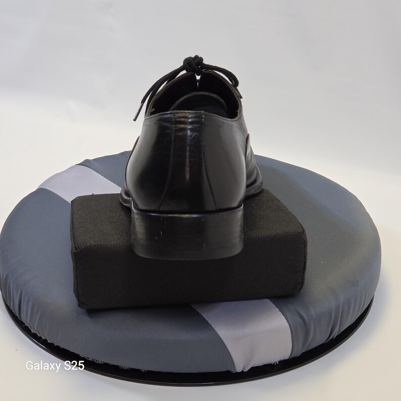 Puede incluir: Un zapato tipo oxford de cuero negro con tac&oacute;n bajo, punta redondeada y cordones negros atados en la parte superior. El zapato se muestra desde la parte posterior, destacando el contrafuerte de cuero liso y los detalles de costura en la parte trasera.