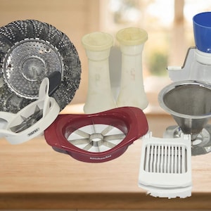 May include: A collection of kitchen tools including a metal steamer basket, two off-white salt and pepper shakers, a blue and white food processor attachment, a metal coffee filter, a white egg slicer, and two fruit slicers in white and red.