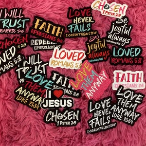 May include: A collection of assorted vinyl stickers featuring religious quotes and phrases such as I Will Trust, Faith, Love Never Fails, Be Joyful Always, Loved, Love Them Anyway, and I Heart Jesus, rendered in various colorful fonts and black outlines.