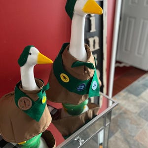 May include: A white ceramic mug with a black handle and the text "But First, Coffee" in a handwritten style. The mug is on a white surface. The mug is approximately 4 inches tall.