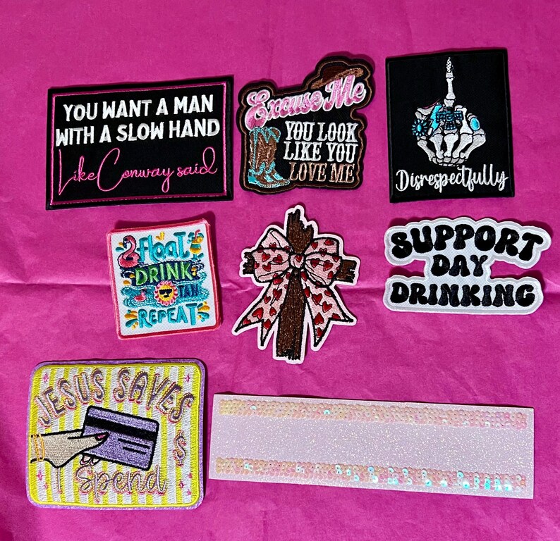 Pode incluir: Cole&ccedil;&atilde;o de patches bordados com v&aacute;rios designs e texto. Inclui patches com frases como "You Want a Man With a Slow Hand", "Excuse Me You Look Like You Love Me" e "Jesus Saves Spend".