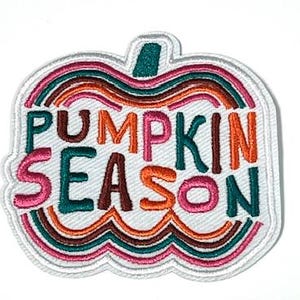 May include: Embroidered patch in the shape of a pumpkin with the words "PUMPKIN SEASON" in teal, orange, and pink. The patch has a white border and a teal stem. The design features a rainbow-like pattern.