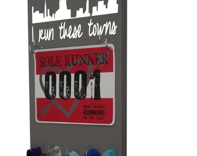 Display your race bibs and running medals with this I run these towns or I run this town holder