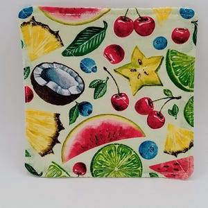 Puede incluir: Posavasos cuadrado de tela con fondo verde claro y un colorido estampado de frutas. El diseño incluye sandía, cerezas, arándanos, carambola, piña, coco y rodajas de lima.