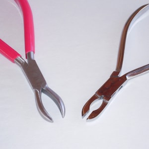 May include: Two pairs of pliers with different handle styles. One pair has red handles and the other has silver handles.