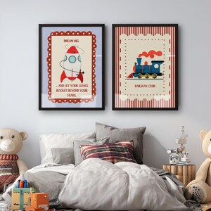 May include: Two framed art prints with black borders. One features a rocket with the text "Dream Big...and let your goals rocket beyond your fears." The other shows a blue train with the text "Railway Club."