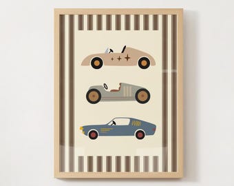 May include: A framed print featuring three vintage-style race cars in beige, gray, and blue. The cars have black and brown wheels and are set against a cream background with vertical brown stripes. The frame is light brown.