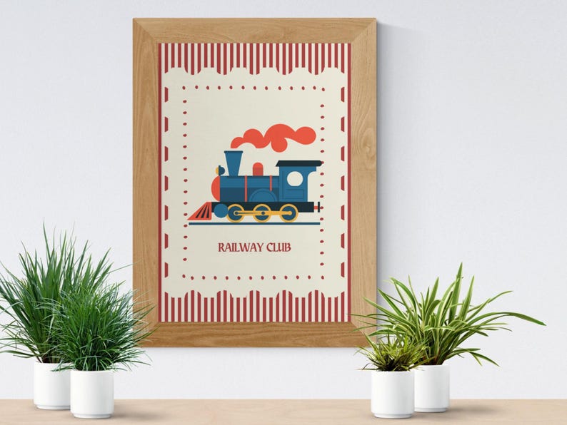 May include: A framed print featuring a blue train with red smoke, set against a cream background with a red and white border. The text "RAILWAY CLUB" is below the train. The frame is made of light brown wood.