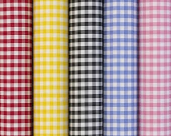 May include: Five vertical rolls of fabric featuring a classic gingham check pattern. The rolls are arranged side by side in red, yellow, black, blue, and pink, each alternating with white to create a consistent, repeating square grid design.