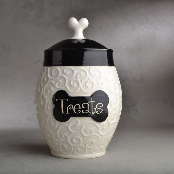 May include: White ceramic dog treat jar with a black lid and a black bone-shaped label that says "Treats".