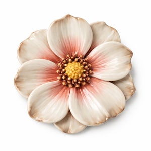Op de afbeelding: Een keramische bloem met een gedetailleerd ontwerp. De bloemblaadjes zijn crèmewit met roze en bruine accenten. Het midden van de bloem is geel en bruin. De bloem is waarschijnlijk een decoratief item.