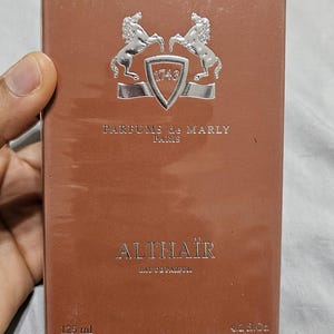 May include: A brown perfume box with the text "ALTHA&Iuml;R Eau de Parfum" and "PARFUMS de MARLY PARIS". The box has a silver emblem with two horses and the number "1743". The box contains 125 ml (4.2 fl oz).