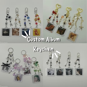 Puede incluir: Una colección de llaveros de álbum personalizados con dijes fotográficos cuadrados de acrílico unidos a cierres plateados o dorados. Cada llavero está decorado con varias cuentas, dijes y lazos. Se muestra el texto Custom Album Keychain.