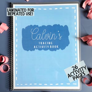 May include: A laminated tracing activity book with a light blue cover. The cover features the text "Calvin's Tracing Activity Book" in white script. The book includes 26 activity pages and is designed for repeated use.
