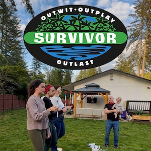 May include: A group of people playing a game outdoors with a "Survivor" logo in the background. The logo is black with green and blue accents. People are standing on a wooden plank, and a child is playing on the grass.