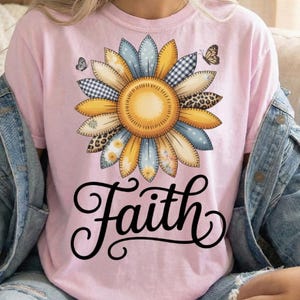 May include: A light pink t-shirt featuring a large sunflower design with various patterns and colors, including blue, yellow, and leopard print. The word "Faith" is written in a cursive font below the flower. The top includes the text "2 PNG FILES INCLUDED".