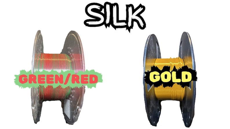 May include: Image of two spools of silk thread. One spool is filled with green and red thread, labeled "GREEN/RED". The other spool is filled with gold thread, labeled "GOLD". The word "SILK" is above the spools.