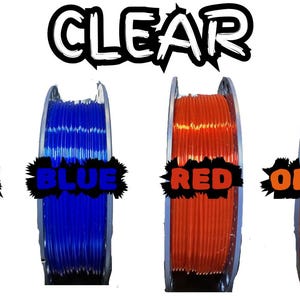May include: Four spools of 3D printing filament in clear, blue, red, and orange. Each spool is labeled with its respective color name in a stylized font. The word "CLEAR" is written above the spools in a similar font.