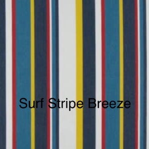 May include: A fabric pattern featuring vertical stripes in navy blue, white, yellow, red, and teal. The text Surf Stripe Breeze is printed in black across the center of the fabric, which displays a repeating sequence of these colored stripes.