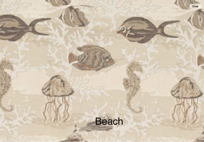 May include: A beige fabric featuring a repeating pattern of brown fish, jellyfish, and seahorses interspersed with white coral motifs. The word Beach is printed in black text near the bottom center of the design on the light background.