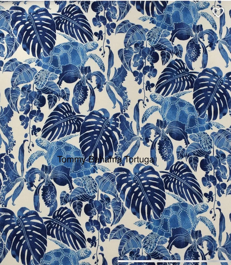 Peut inclure: Un tissu avec un motif r&eacute;p&eacute;titif de tortues de mer bleues, de feuilles tropicales et d'orchid&eacute;es sur un fond cr&egrave;me. Le texte "Tommy Bahama Tortuga" est visible. Le motif est de style aquarelle avec diff&eacute;rentes nuances de bleu.
