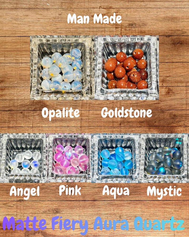 Op de afbeelding: Een assortiment kleurrijke, door de mens gemaakte kralen in vierkante glazen bakjes. De kralen zijn gelabeld met "Opalite", "Goldstone", "Angel", "Pink", "Aqua" en "Mystic". De tekst "Man Made" en "Matte Fiery Aura Quartz" zijn ook zichtbaar.