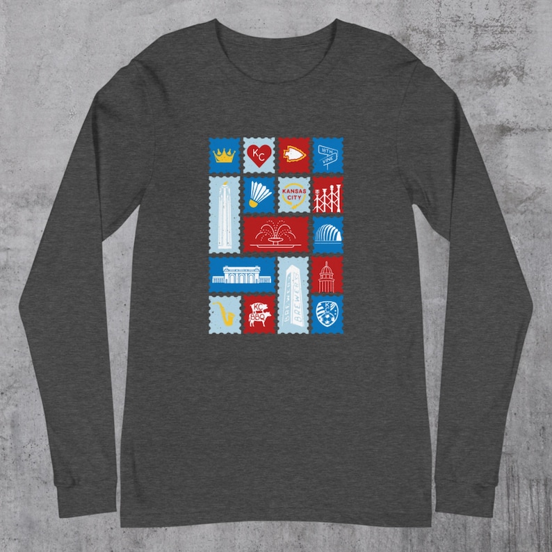 May include: A dark gray long-sleeve shirt featuring a colorful graphic of postage stamp designs. The stamps depict various Kansas City landmarks and symbols, including a crown, heart, and the words "Kansas City".