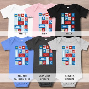May include: A collection of six baby onesies in various colors: white, pink, black, heather Columbia blue, dark grey heather, and athletic heather. Each onesie features a colorful stamp-like design with the text "Kansas City".
