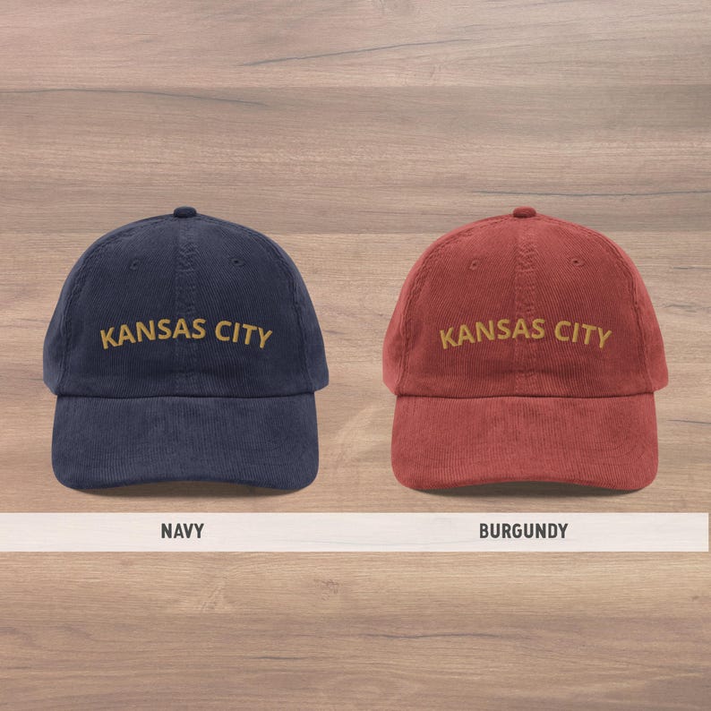 Puede incluir: Se muestran dos gorras de b&eacute;isbol de pana, una azul marino y otra burdeos. Cada gorra tiene bordado "KANSAS CITY" en hilo dorado. La gorra azul marino est&aacute; a la izquierda y la burdeos a la derecha. Estilo cl&aacute;sico.