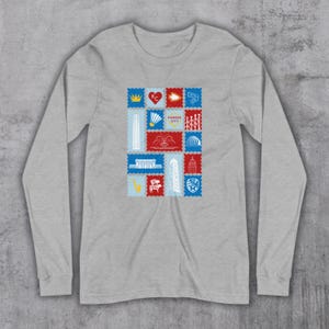 May include: A long-sleeved, heather gray shirt featuring a collection of colorful postage stamp designs. Each stamp showcases a different Kansas City landmark or symbol, including a crown, heart, and fountain. The stamps are arranged in a grid pattern.