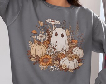 May include: Charcoal gray sweatshirt featuring a whimsical illustration of a ghost surrounded by pumpkins, flowers, and foliage. The design has a fall theme. The word "Charcoal" is printed at the bottom left.