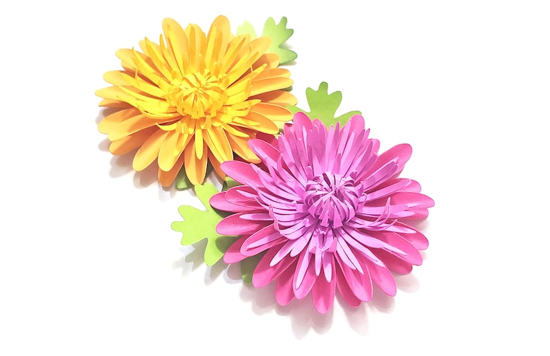 K&ouml;nnte beinhalten: Zwei Papierblumen, eine gelbe und eine rosa, mit gr&uuml;nen Papierbl&auml;ttern.