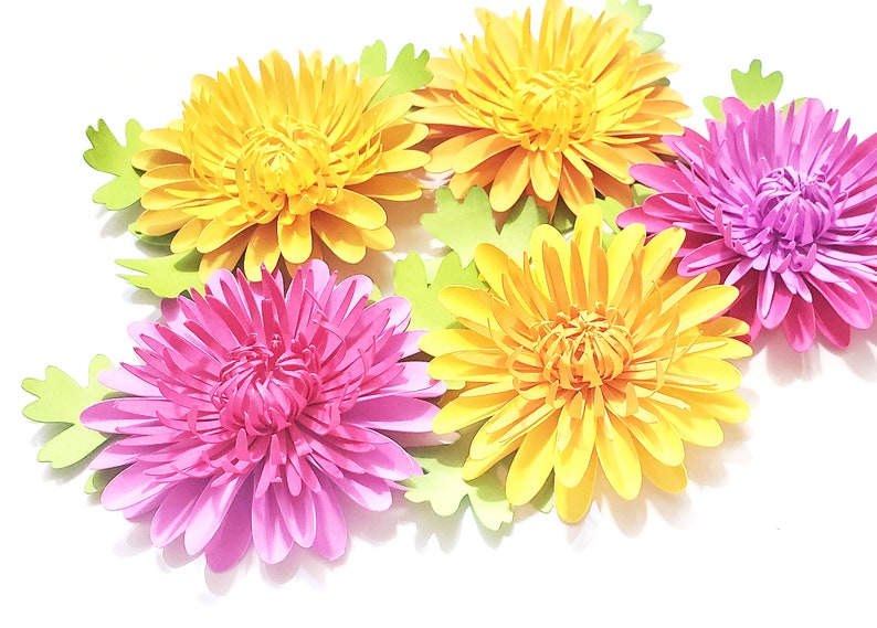 K&ouml;nnte beinhalten: F&uuml;nf Papierblumen in den Farben Gelb und Rosa. Die Blumen sind geschichtet und haben einen 3D-Effekt. Die Blumen sind in einer Gruppe auf einem wei&szlig;en Hintergrund angeordnet.