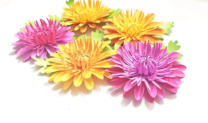 K&ouml;nnte beinhalten: F&uuml;nf Papierblumen, zwei gelbe und drei rosa, mit gr&uuml;nen Papierbl&auml;ttern. Die Blumen sind &uuml;bereinander gelegt und haben einen 3D-Effekt.